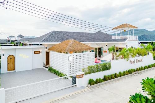 Casa blanca con techo de paja en Pool House Pool Villa Cha-Am, en Cha Am