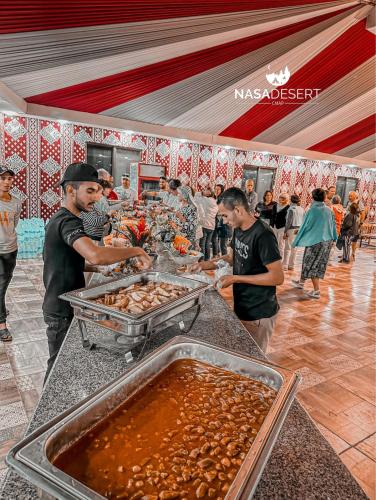 a group of people preparing food at a buffet at Nasa desert luxury camp in Wadi Rum
