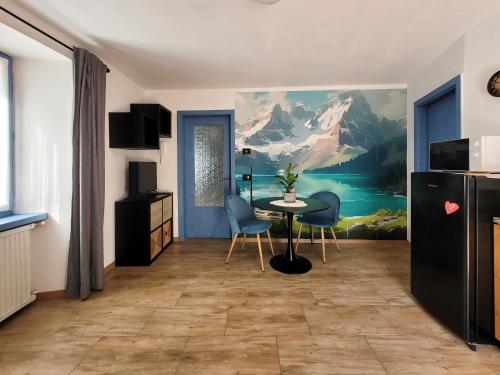 ein Esszimmer mit einem Tisch, Stühlen und einem Gemälde in der Unterkunft Maison AnnaBelle in Ceniga