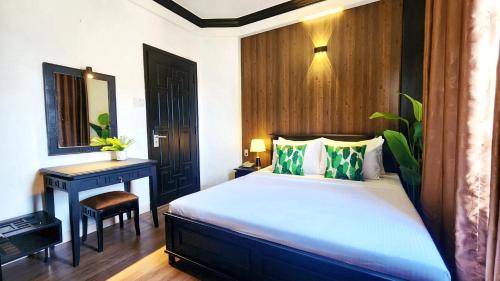 a bedroom with a bed and a table and a mirror at Rosa May Hotel in Ho Chi Minh City