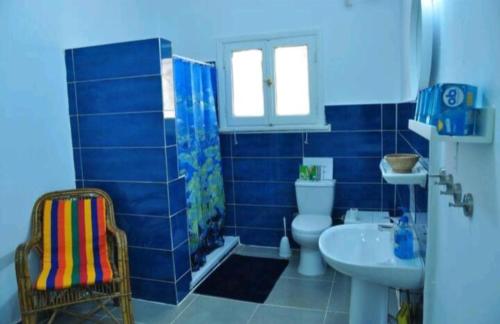 Baño de azulejos azules con aseo y lavamanos en La Casa pyramids Inn en El Cairo