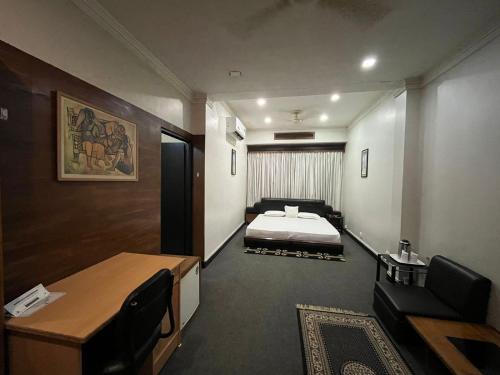 a hotel room with a bed and a desk and a desk at Hotel The Galaxy in Mirzāpur