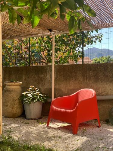 a red chair sitting under a pergola at B&B La Magnolia in Savona