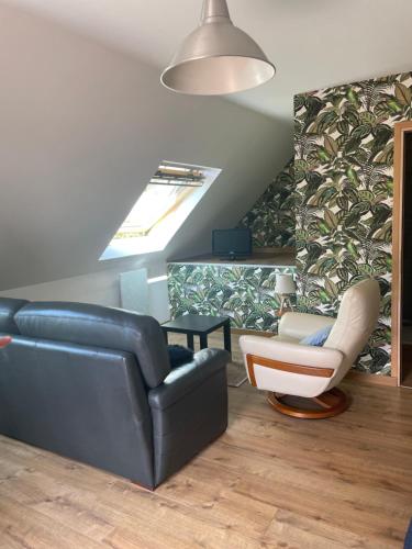 a living room with a couch and a chair at petit studio in Steenbecque