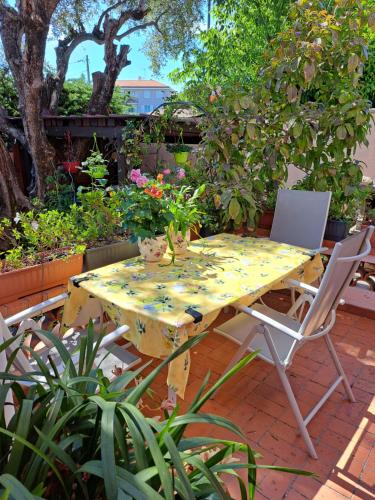 a table and chairs on a patio with plants at la chambre de CLEO in Cannes