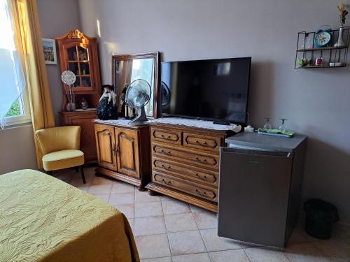 a bedroom with a tv and a dresser with a mirror at la chambre de CLEO in Cannes