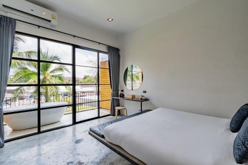 a bedroom with a bed and a tub and a window at Book a Bed Poshtel - SHA Plus in Phuket Town