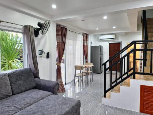 a living room with a couch and a staircase at Phujhaofa villa club ( ไสยวน) in Ban Saiyuan (1)