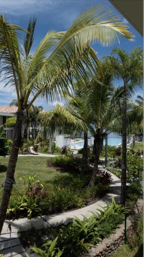 un jardín con palmeras y una pasarela en Tahiti Chalala, en Paea