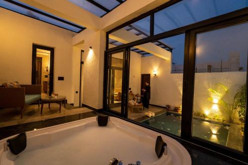 a large bathroom with a tub and a large window at The Golden Tusk By Ivory Destinations in Rāmnagar