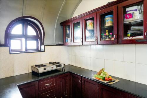 a kitchen with wooden cabinets and a counter top at Aqua Castle Houseboat - by Aqua Jumbo Houseboats in Alleppey