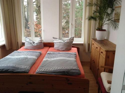 1 cama con almohadas en una habitación con ventanas en Bernstein Comfortable holiday residence, en Heringsdorf