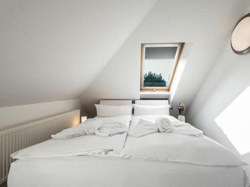 a white bed in a room with a window at Water Comfortable holiday residence in Ostseebad Koserow