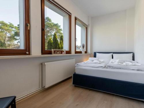 a bedroom with a bed and two windows at Autumn Comfortable holiday residence in Ostseebad Karlshagen