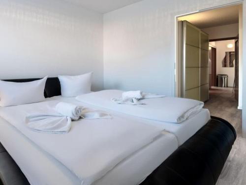 a large white bed with two white towels on it at Fire Comfortable holiday residence in Ostseebad Koserow