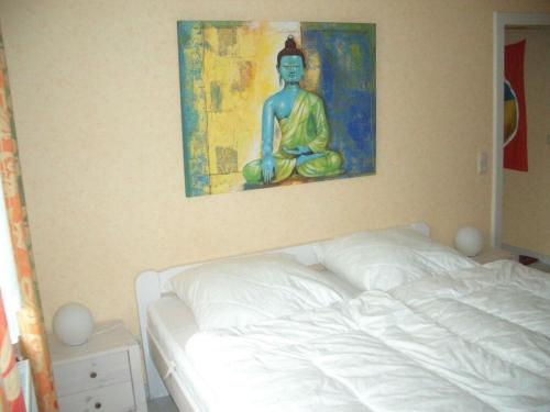 a bed in a bedroom with a painting on the wall at Picobello 2 Comfortable holiday residence in Timmendorfer Strand