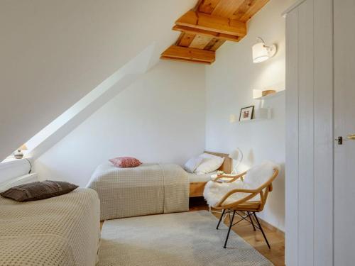 a attic room with two beds and a chair at Huus Uelvesbüll South-West in Uelvesbüll