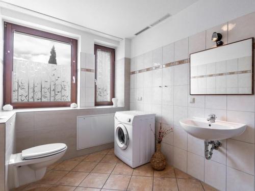 a bathroom with a washing machine and a sink at Winter Comfortable holiday residence in Ostseebad Karlshagen