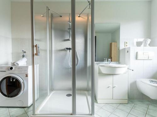 a bathroom with a washing machine and a sink at Air Comfortable holiday residence in Ostseebad Koserow