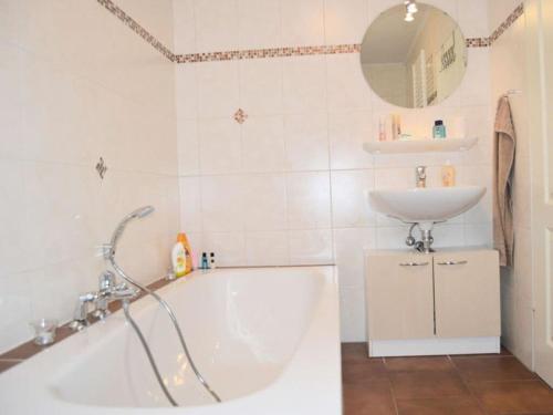 uma casa de banho com uma banheira e um lavatório em Deichjuwel Comfortable holiday residence em Norddeich