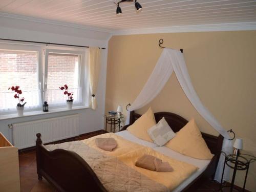1 dormitorio con 1 cama grande con dosel en Deichjuwel Comfortable holiday residence en Norddeich