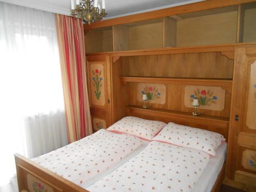 a bedroom with a bed with a wooden headboard at Ferienwohnung Fred in Hollersbach im Pinzgau