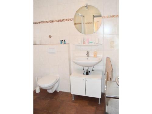 uma casa de banho com um lavatório, um WC e um espelho. em Windrose Comfortable holiday residence em Norddeich