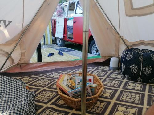 a room with a tent and a basket of books at MES NUITS VINTAGE EN COMBI in Robion en Luberon
