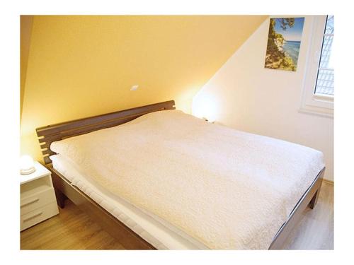 un letto in una camera da letto con parete gialla di Seewind Comfortable holiday residence a Breege