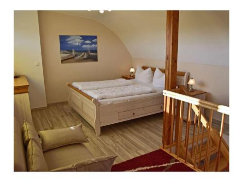 a bedroom with a large bed and a staircase at Bella Casa 36 - Mones in Juliusruh