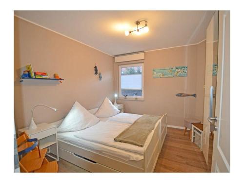 a bedroom with a bed with a desk and a window at Finn Comfortable holiday residence in Juliusruh