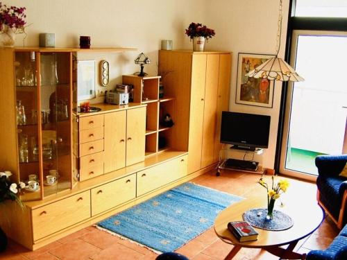 a living room with a large wooden entertainment center at Ferienwohnung Mester mit Schwimmbad Sauna in Bad Harzburg