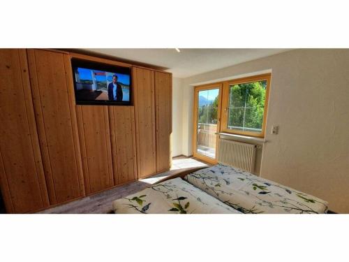 um quarto com uma cama e uma televisão de ecrã plano em Alpine Lodge Comfortable holiday residence em Wertach