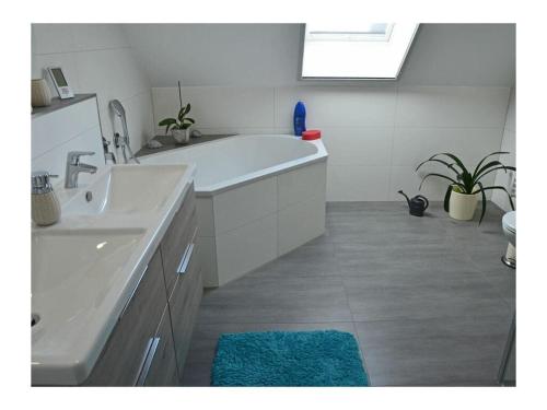 a white bathroom with a tub and a sink at Starfish Comfortable holiday residence in Breege