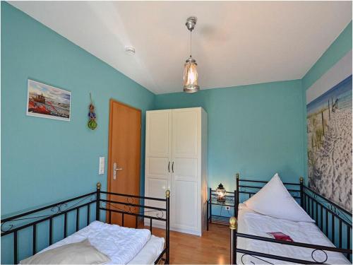 a bedroom with two bunk beds and blue walls at Albatros Comfortable holiday residence in Juliusruh