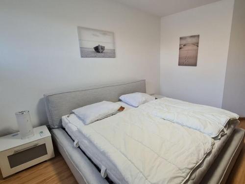a bed in a bedroom with two pictures on the wall at Earth Comfortable holiday residence in Ostseebad Koserow