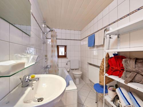 La salle de bains blanche est pourvue d'un lavabo et de toilettes. dans l'établissement Greif Comfortable holiday residence, à Garmisch-Partenkirchen
