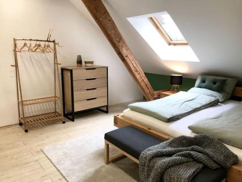 een slaapkamer met een bed en een dressoir op zolder bij Böllenburg Comfortable holiday residence in Bernbeuren