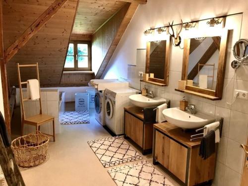 een badkamer met 2 wastafels en een wasmachine bij Böllenburg Comfortable holiday residence in Bernbeuren