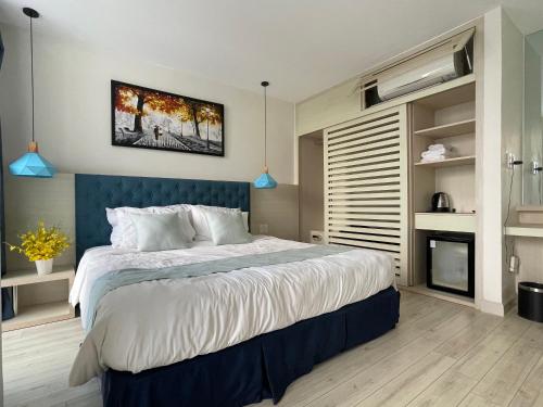 a bedroom with a large bed with a blue headboard at Villa Oceanami - phước hải - bà rịa - vũng tàu in Long Hai