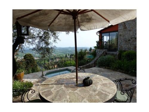 - une table avec un parasol sur la terrasse dans l'établissement Romantisch stenen huis, à Châteauneuf