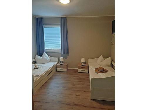 a small room with two beds and a window at Carlo Comfortable holiday residence in Juliusruh