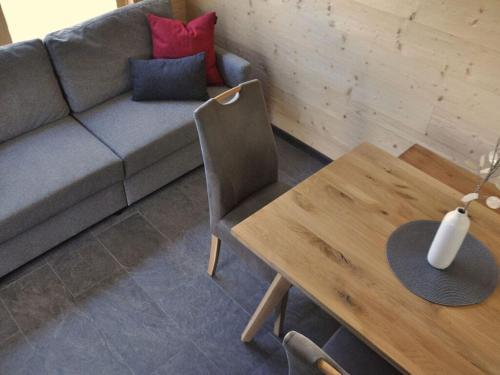 a living room with a couch and a wooden table at Kellerwald Chalet Comfortable holiday residence in Vöhl