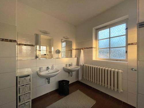 a bathroom with two sinks and a window and a radiator at Villa Sommerfeld 