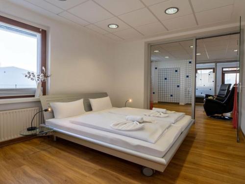a large white bed in a room with a window at Spring Comfortable holiday residence in Ostseebad Karlshagen