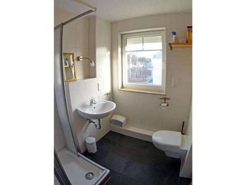 a bathroom with a sink and a toilet and a shower at At the Dune Comfortable holiday residence in Juliusruh