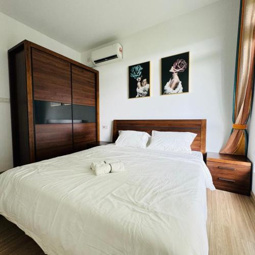 a bedroom with a large white bed with two towels on it at Cozy 2B1R condo Forest City in Gelang Patah