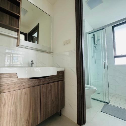a bathroom with a sink and a toilet and a mirror at Cozy 2B1R condo Forest City in Gelang Patah