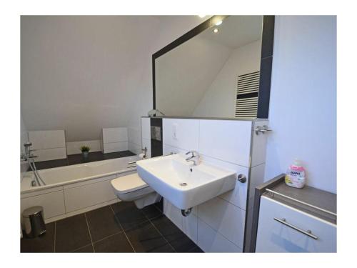 un bagno con lavandino, WC e vasca di Pameebo 1 Comfortable holiday residence a Drewoldke