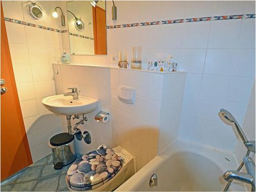 a bathroom with a sink and a bath tub at Evening sun Juliusruh in Juliusruh